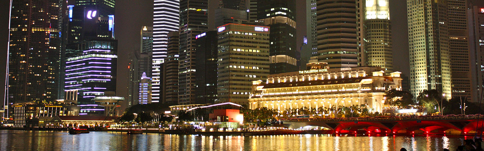 Singapore's waterfront skyline of modern buildings, brightly lit at night.